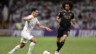 Al Ain's Mathias Palacios, left, runs with the ball under pressure from Al Sadd's Akram Afif during the AFC Champions League match at Hazza bin Zayed Stadium on September 16, 2024. Getty