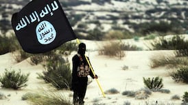 An ISIS fighter carrying the group's flag in 2015. US troops are stationed in Iraq and Syria as part of an international coalition to fight the remnants of ISIS. Getty Images