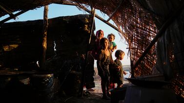 Children stand in front of their traditional reed house in the Chebayesh marshes, Nasiriyah, Iraq.  AP Photo