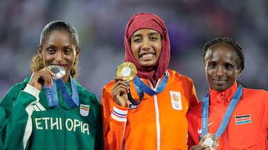 Women's marathon gold medalist Sifan Hassan, centre, of the Netherlands, stands with silver medalist Tigst Assefa of Ethiopia, and bronze medalist Hellen Obiri, right, of Kenya. AP