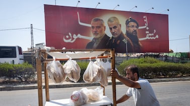 In Beirut, a street seller pushes his food cart past a billboard depicting Hamas leader Ismail Haniyeh, Gen Qassem Suleimani, who served in the Iranian Islamic Revolutionary Guard Corps, and senior Hezbollah commander Fouad Shukr, all significant figures for the Axis of Resistance now deceased. Getty Images