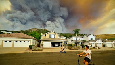 Smoke from an airport fire that started a wildfire in Trabuco Canyon, California, rises behind homes in nearby Meander Lane on Monday, September 9. AP Photo