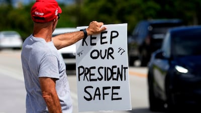 A supporter of Republican presidential nominee Donald Trump holds a sign of support outside of Trump's Mar-a-Lago estate on September 17. AP
