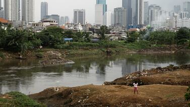 Childrens are seen playing in one of slum area with skyscrapers as background in Jakarta, highlight soaring global inequalities. Getty Images