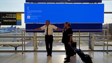 United Airlines employees wait by a departures monitor displaying a blue error screen, also known as the 'Blue Screen of Death' at Newark International Airport, after United Airlines grounded flights due to the worldwide tech outage. Reuters