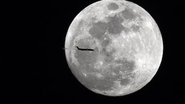 An aircraft passes across a supermoon viewed in Georgia in the US in 2018. A blue supermoon will be visible in the UAE on August 19. Photo: USA Today Sports