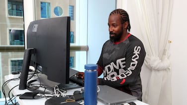 British software programmer Kriss Harris at his desk in a one-bedroom Dubai Marina apartment. Chris Whiteoak / The National