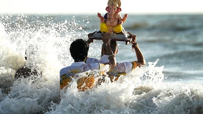 Devotees immerse an idol of the elephant-headed Hindu god Ganesha in the Arabian Sea, during the 10-day Ganesh Chaturthi festival in Mumbai, India.  AP Photo